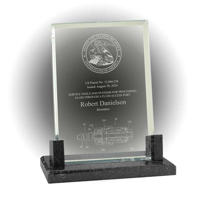 Clear glass patent and inventor award on black marble base, engraved with USPTO seal and patent illustration
