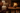 Cozy living room with a lit light bulb on a wooden block in front of a fireplace.